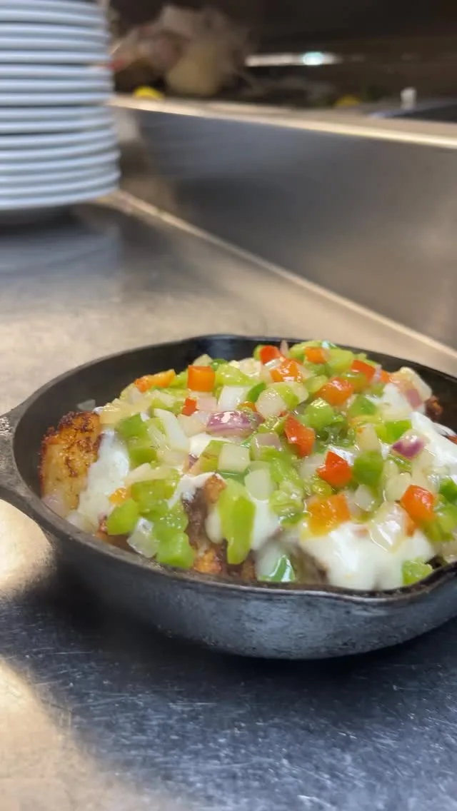 Spice up your week with our Breakfast Tot-Chos Skillet 🫑 Sautéed peppers and onions layered on crispy house-made tots with white gravy, two scrambled eggs, pickled jalapeños and green onions. Try at Wild Eggs thru 8/26!